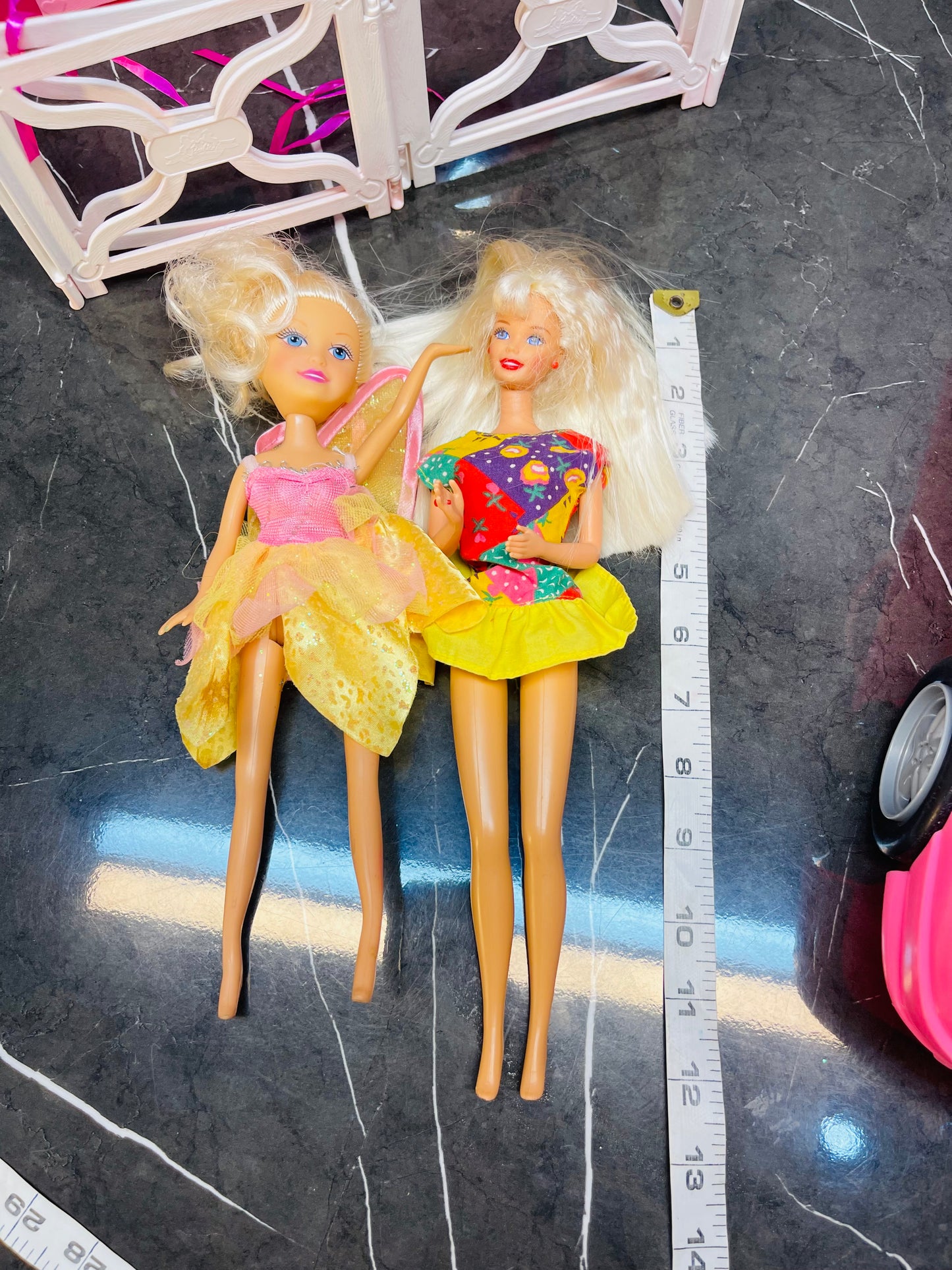 Barbie Glam Convertible car along with two Barbie dolls and a small playhouse.