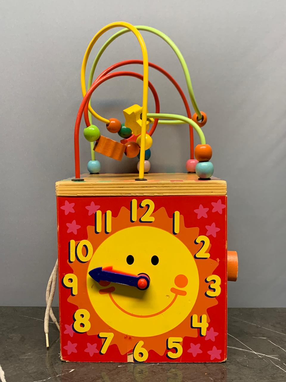 Wooden activity cube, a multi-sided toy.